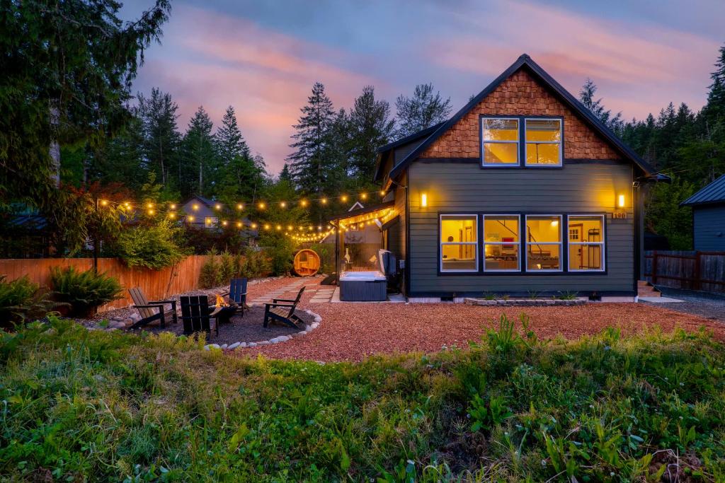 a home with a lit up yard at night at Rainier Spa Cabin 7 Minutes to Park in Ashford