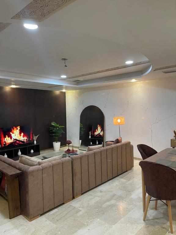 a living room with a large couch and a fireplace at Appartement cozy in Oujda