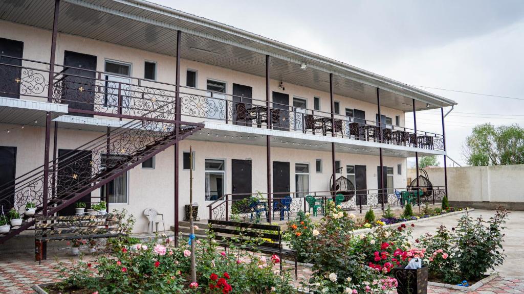 a building with a balcony with flowers and plants at Бархат плюс in Tossor