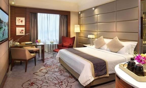 a hotel room with a large bed and a desk at Alaknanda lodge in Varanasi