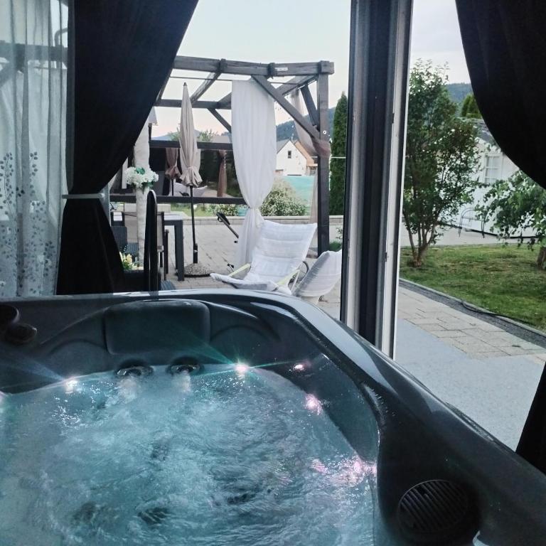 eine Badewanne mit Blick auf eine Terrasse in der Unterkunft ForRest Spa Apartment - Private Jacuzzi & Sauna in Ravna Gora