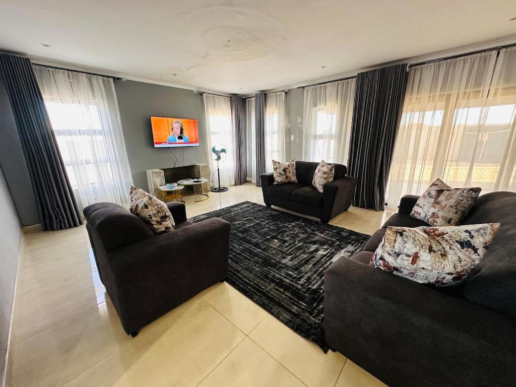 ein Wohnzimmer mit zwei Sofas und einem Sofa in der Unterkunft SimPhil Haven in Bulawayo