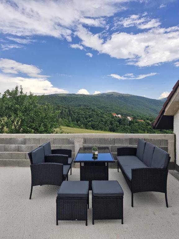 a patio with chairs and a table with a view at Duvnjak Rooms & House in Livno