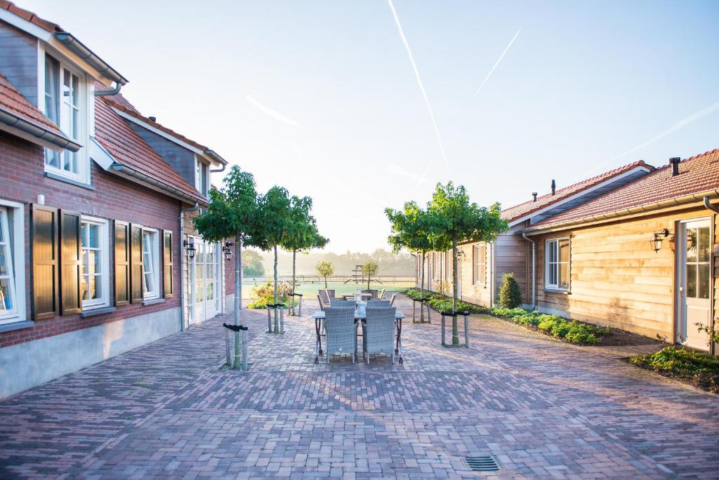a patio with tables and chairs on a brick street at Wertemerhoeve Vakantiewoningen in Evertsoord
