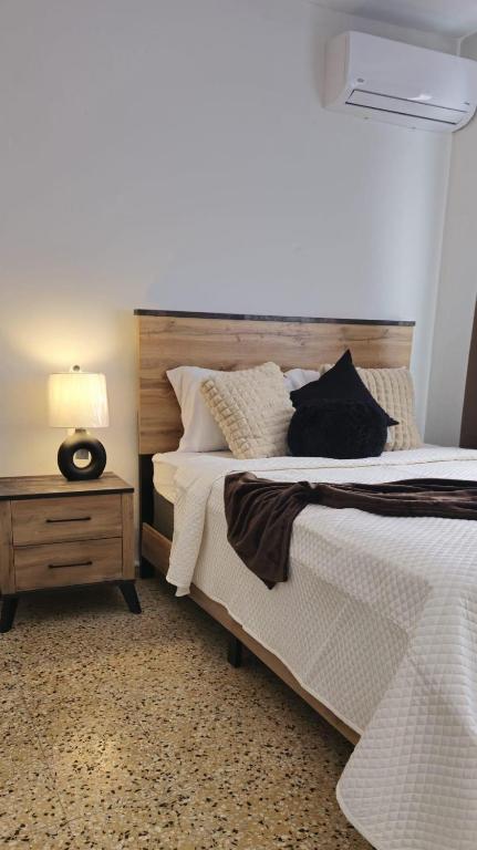 a bedroom with a large bed and a night stand at D'Ponke Guest House in Cayey