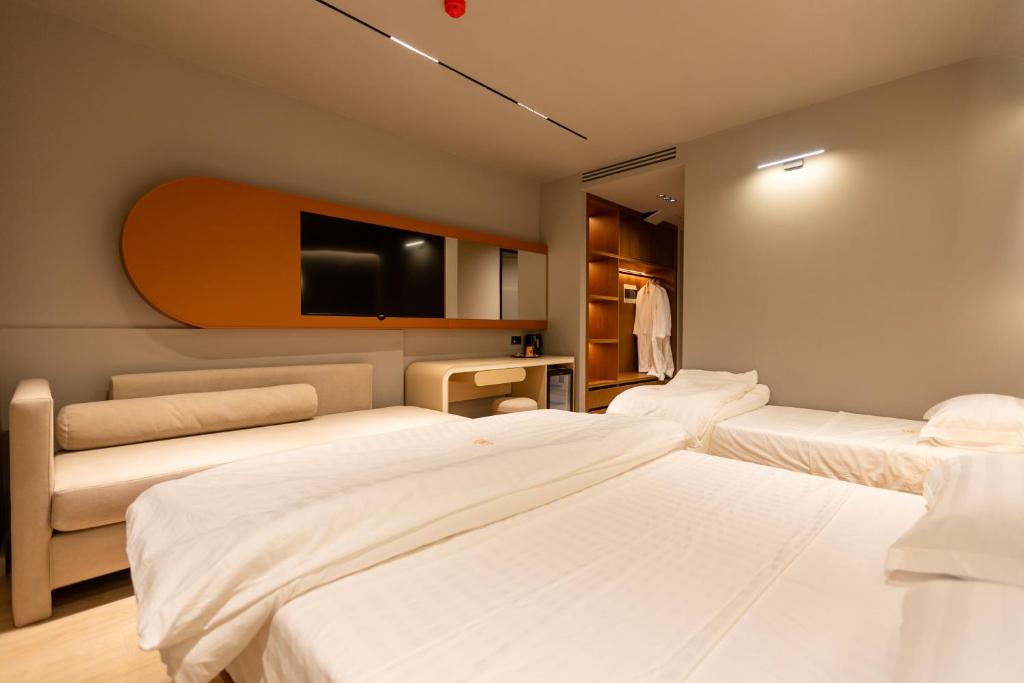 a room with two beds and a flat screen tv at Hotel Berfin in Vlorë