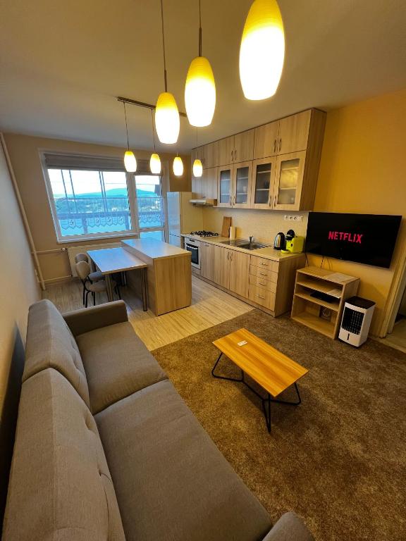 a living room with a couch and a table and a kitchen at Apartmán Košice Nad Jazerom in Košice