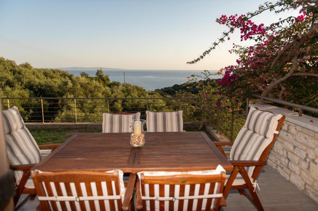 a wooden table and chairs on a patio with a view at Celeste Syvota in Syvota