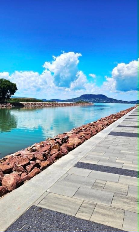 a walkway next to a large body of water at Fonyódi Süllő Garzon in Fonyód