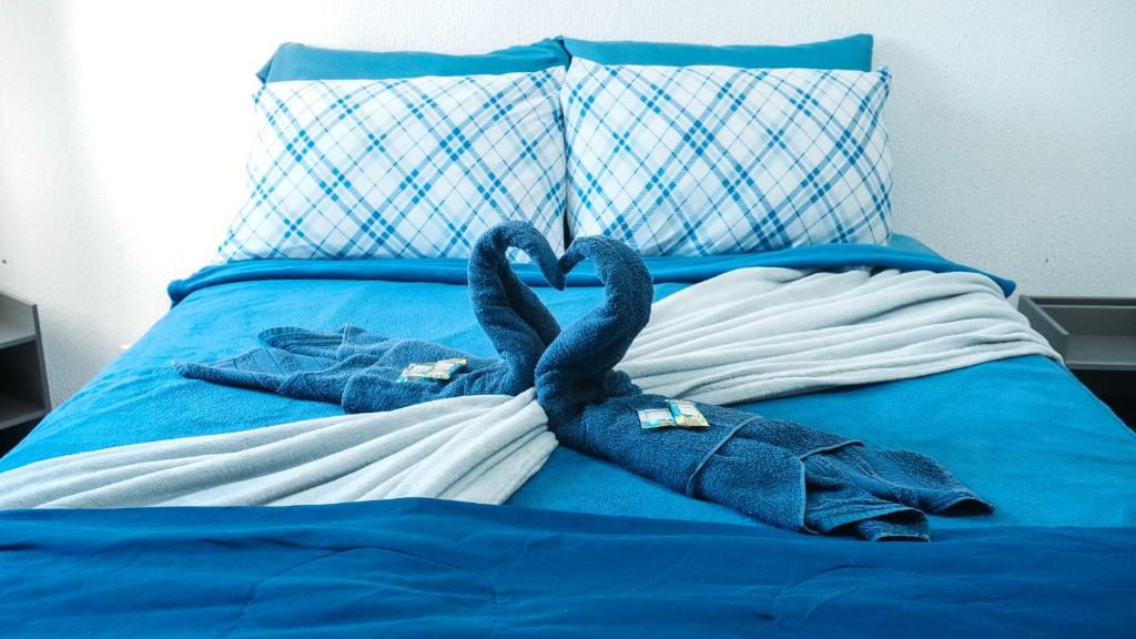 two towel swans sitting on top of a bed at Smart Flat Apart in Mogi das Cruzes