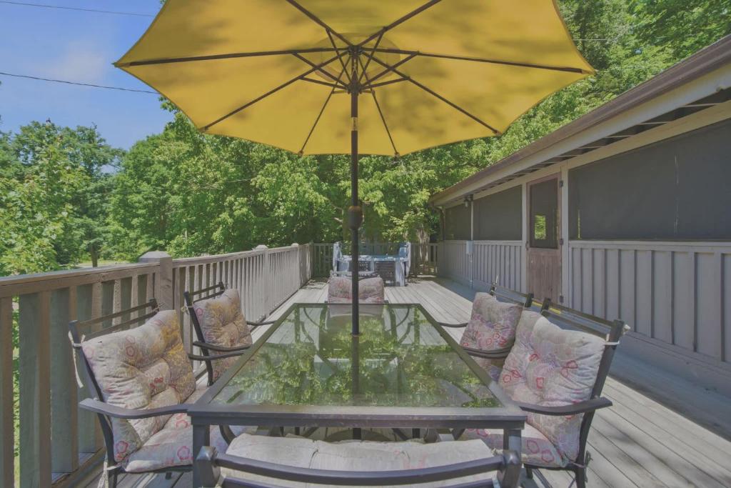 a patio table with a yellow umbrella on a deck at Charming Mtn View Cabin Sleeps 8 Spacious Deck in Townsend