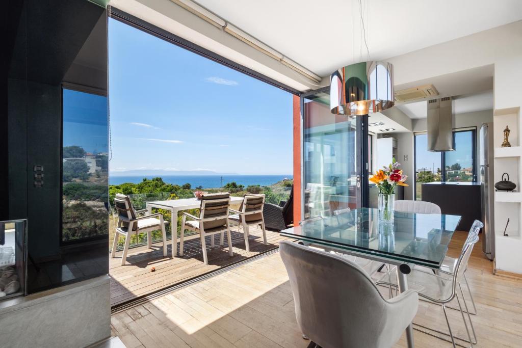 a kitchen and dining room with a glass table at Villa Panorama Kalathas - 4 Bedrooms Near beach in Chorafakia