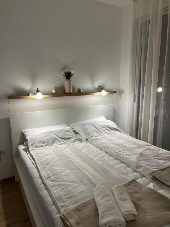 a large white bed with two towels on it at Porodična oaza Vrnjačka Banja in Vrnjačka Banja
