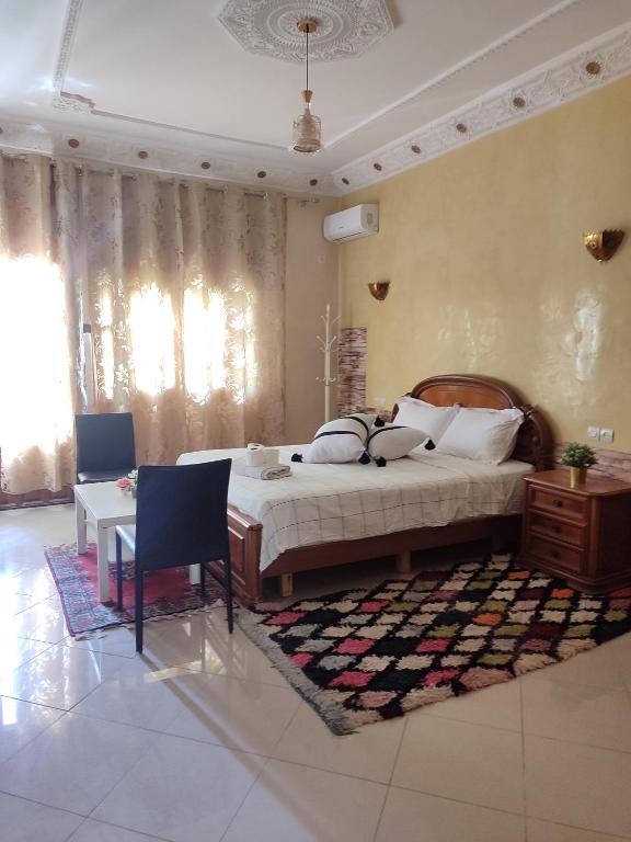 a bedroom with a large bed and a table at Chambre d'hôte in Midelt