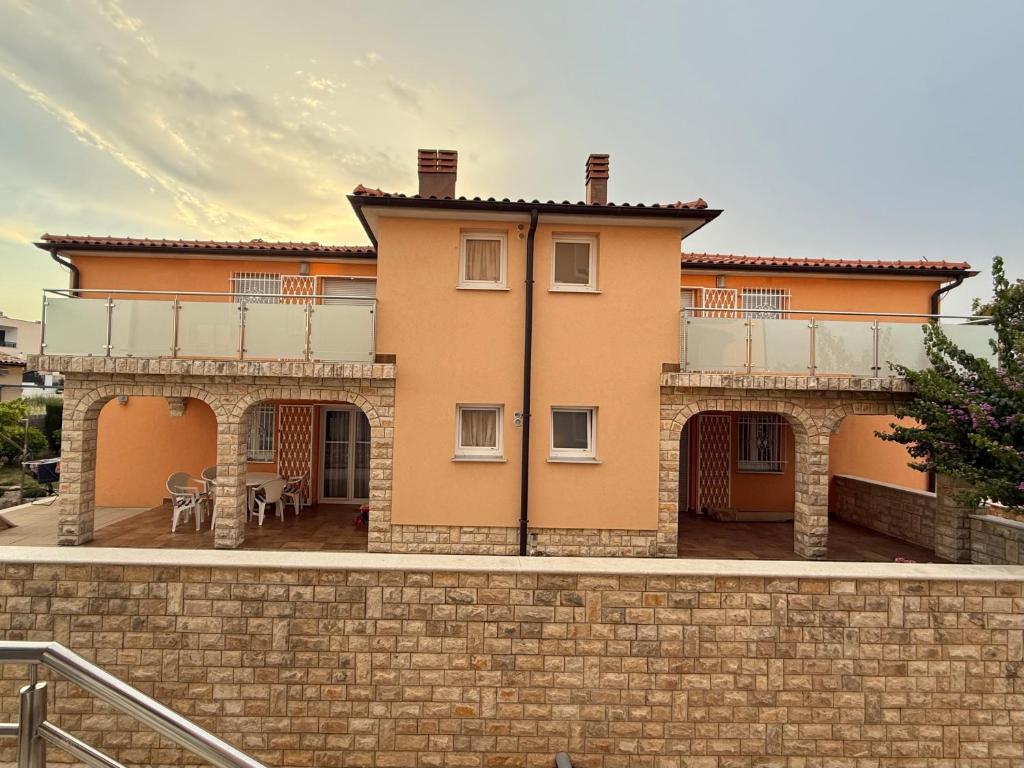a large orange house with a brick wall at Villa Luka in Barbariga