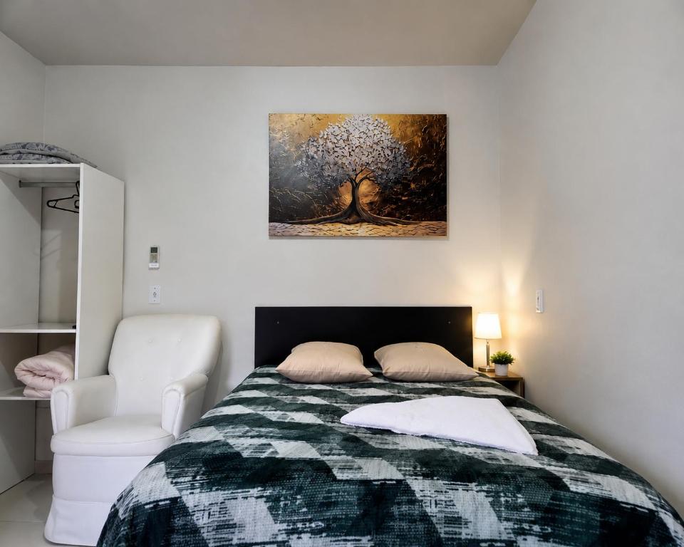 a bedroom with a tree painting on the wall at Hotel Três Passos - Prox ao Aeroporto e Rodoviária in Porto Alegre