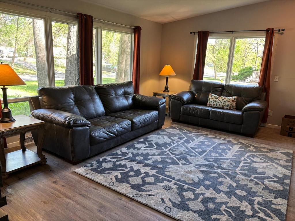 a living room with a leather couch and a rug at Cedarwood Chateau in Cambridge