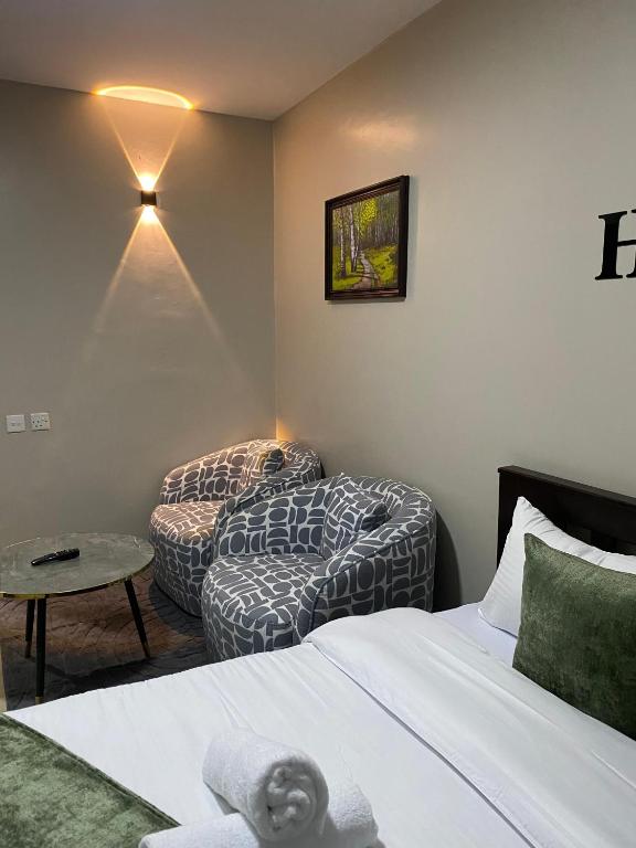 a bedroom with a bed and a chair and a couch at The Cozy Corner Studio in Ruaka