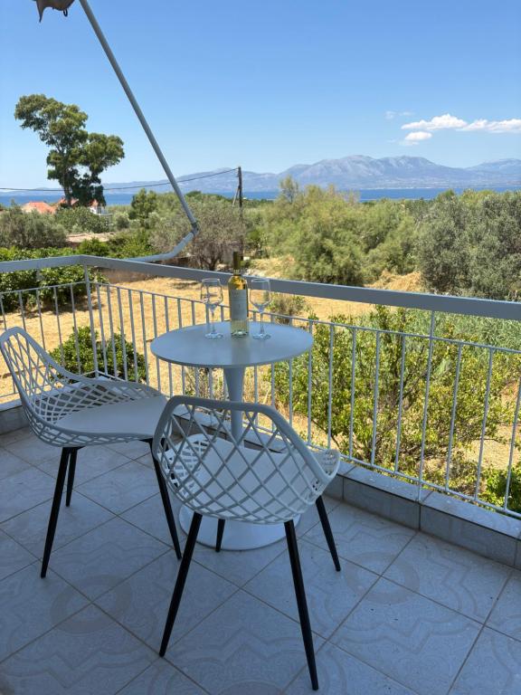 a table and two chairs on a balcony at Yialos Kalamos in Kalamos