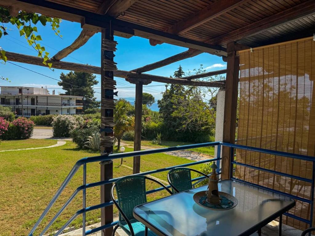 a patio with a table and chairs on a porch at Casa Helios Fourka Beach Retreat in Skala Fourkas