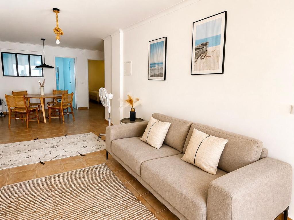 a living room with a couch and a dining room at Accommodation in Sesimbra - Two Double Bedroom in Sesimbra