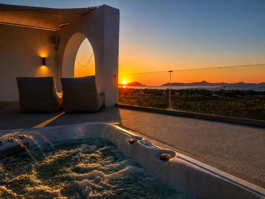 a hot tub in a room with a sunset in the background at iLocal Premium Services suite in Zefiría