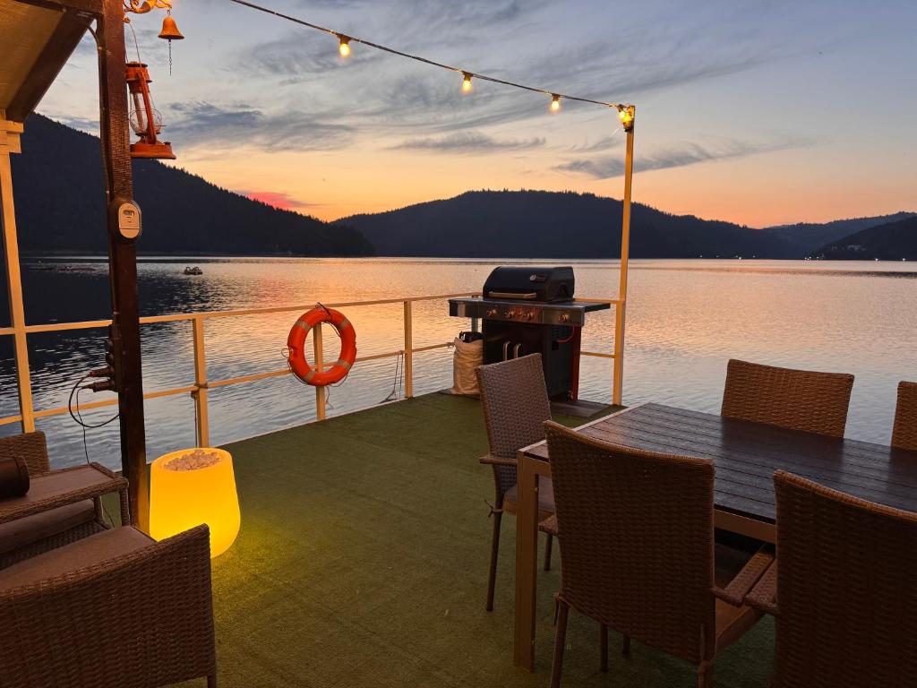 a deck of a boat with a table and chairs at Casa pe lac Bicaz in Bicaz