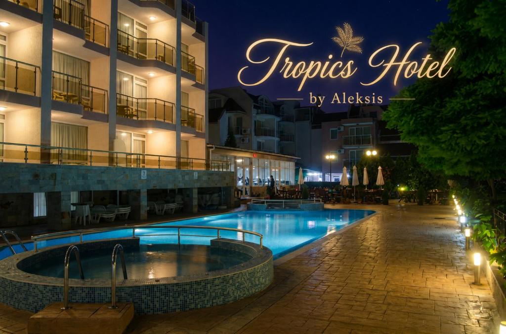 a hotel with a swimming pool at night at Tropics Hotel by Aleksis in Sveti Vlas