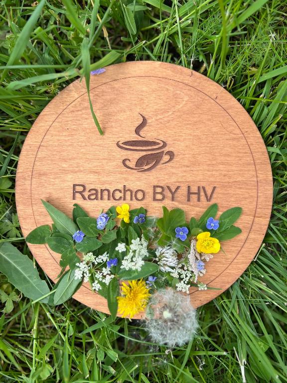 a wooden sign with flowers on the grass at Rancho by HV in Sevan