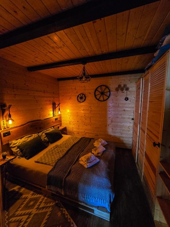 a bedroom with a large bed in a wooden room at Kuća za odmor Štefi in Donji Koncovčak