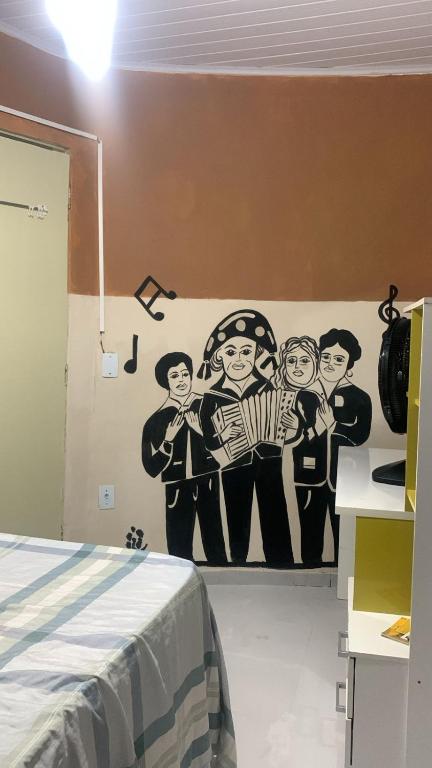 a bedroom with a mural of a band on the wall at Quarto Recando do Sol in Aracaju