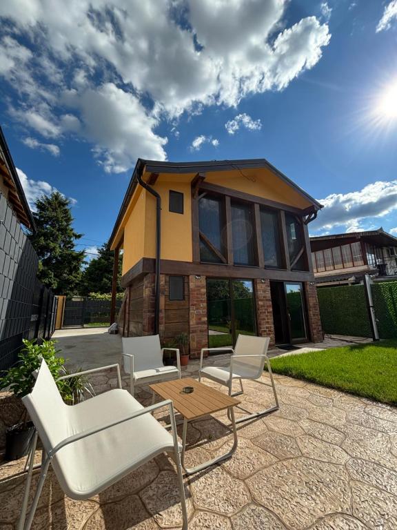 a patio with chairs and a table and a house at Vila Luminis in Seone