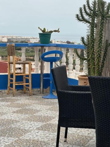 a table and chairs on a balcony with a cactus at DAR SANAE SURF in Aourir