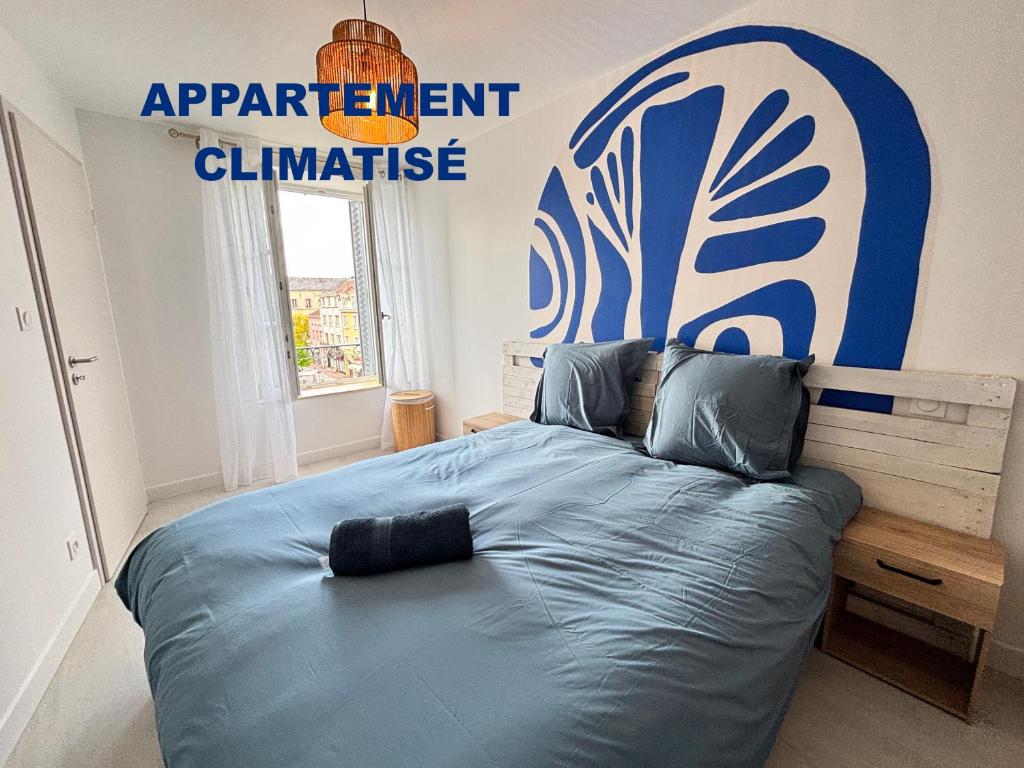 a bedroom with a bed with a sign on the wall at Escapade Santorini Epinal in Épinal