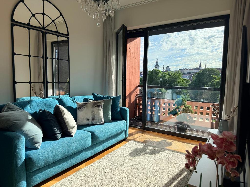 a blue couch in a living room with a large window at Old Town Fabulous view apartment in Tallinn