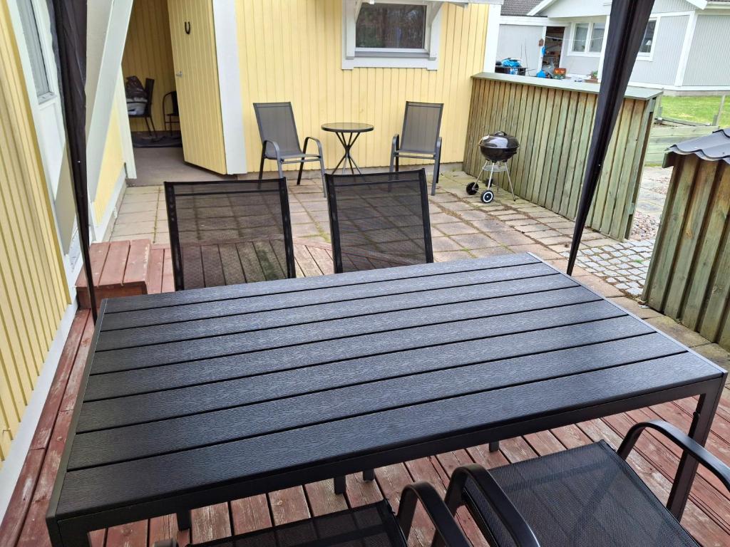 a wooden table and chairs on a patio at bekväm villa in Fliseryd