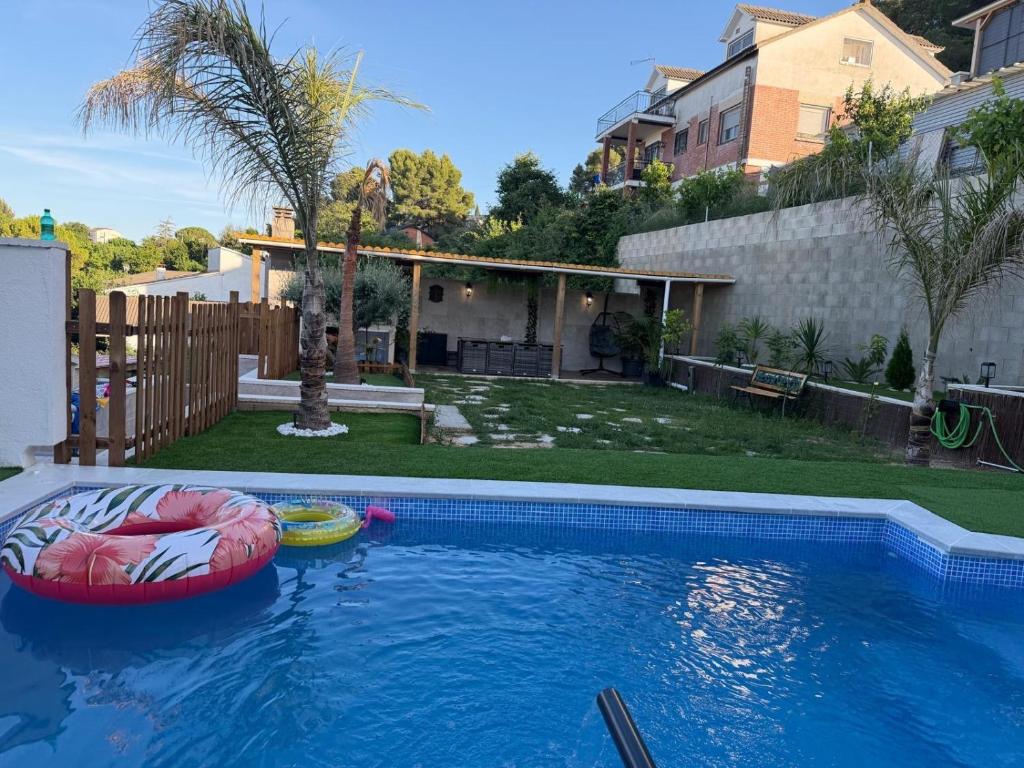a swimming pool with two inflatables in a backyard at Villa Mery Montserrat in Piera