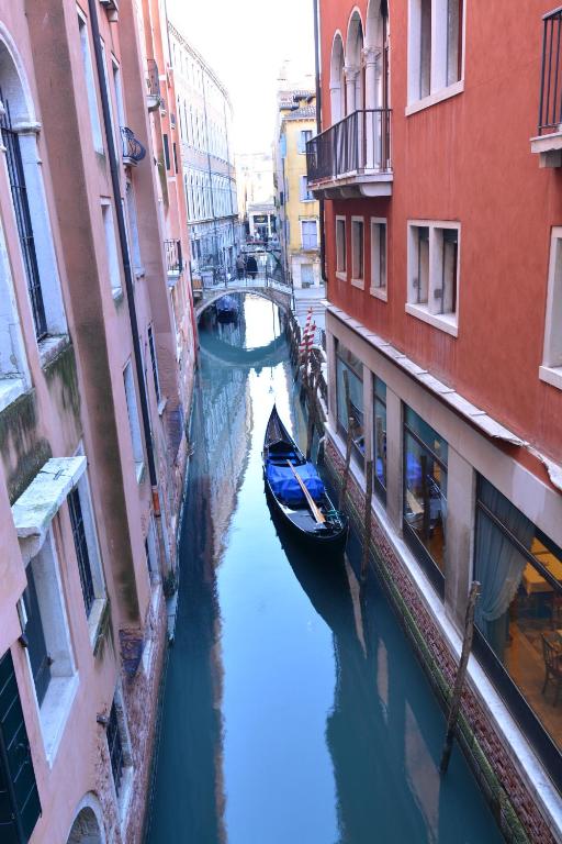 a canal between two buildings with a boat in it at Royal San Marco Hotel in Venice