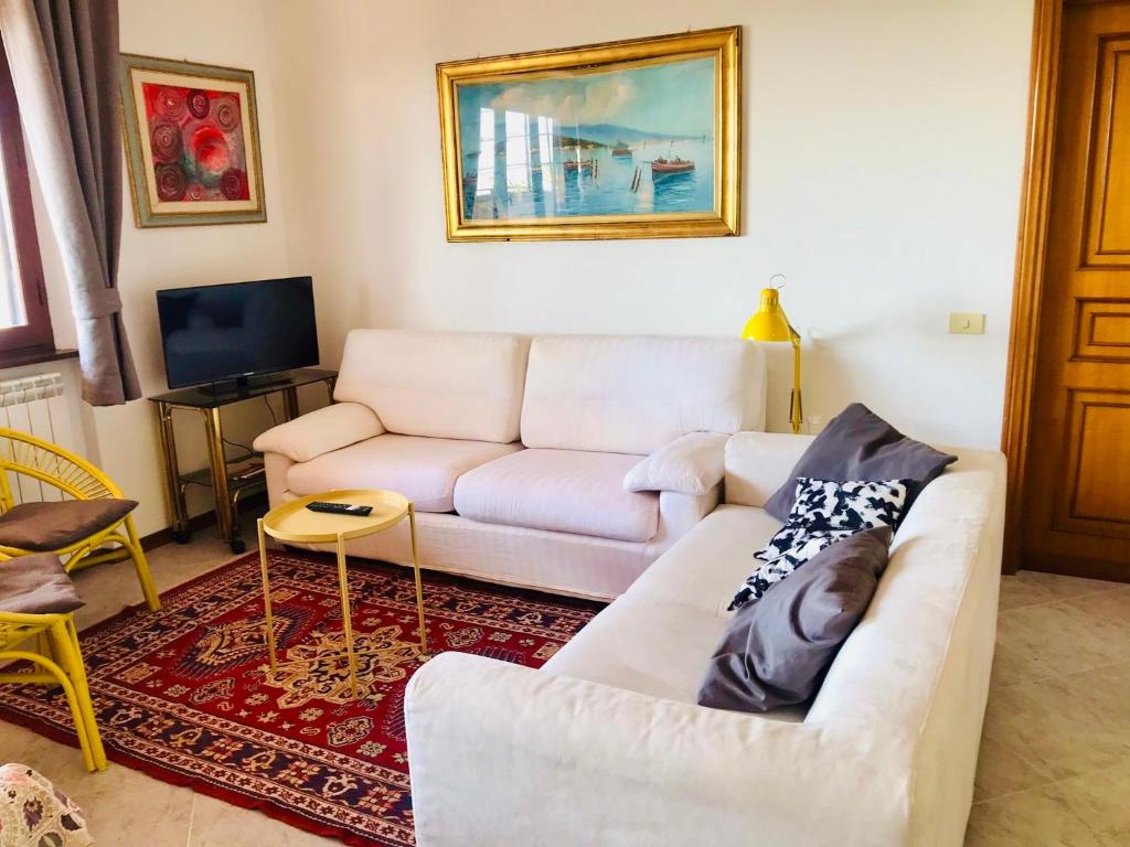 a living room with a white couch and a tv at Appartamento Oscar in Tuoro sul Trasimeno