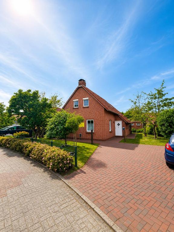 a brick house with a driveway in front of it at Ferienhaus Schonerweg 9 in Norddeich in Norddeich