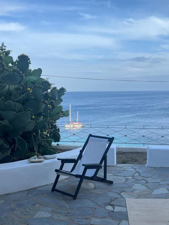 a chair sitting on a patio looking at the ocean at Salt & Sun Terrace Seafront in Agioi Apostoli