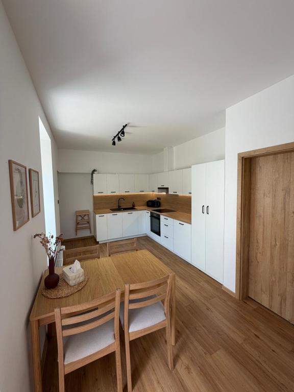 a kitchen and dining room with a table and chairs at Apartmán Mnichov in Vrbno pod Pradědem