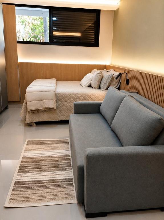 a living room with a couch and a bed at Studio Chico 02 in Espirito Santo Do Pinhal