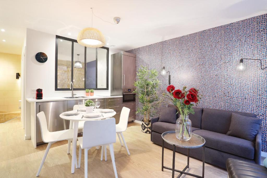un salon avec un canapé et une table avec des fleurs dans l'établissement Rent a Room - Chenier B, à Paris