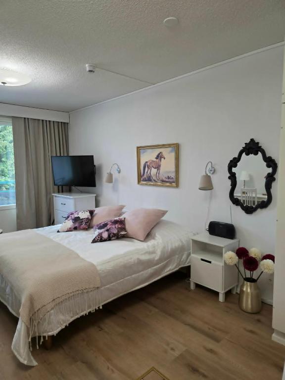 a bedroom with a bed and a table and a mirror at Kylpylä-Hotelli 364 in Ikaalinen