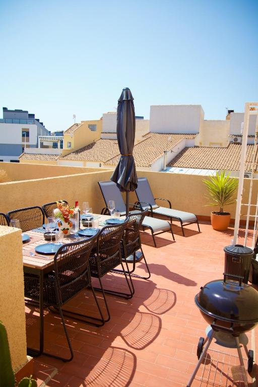 a patio with a table and chairs and an umbrella at Casa Jema - Family house with ocean views in Gran Alacant