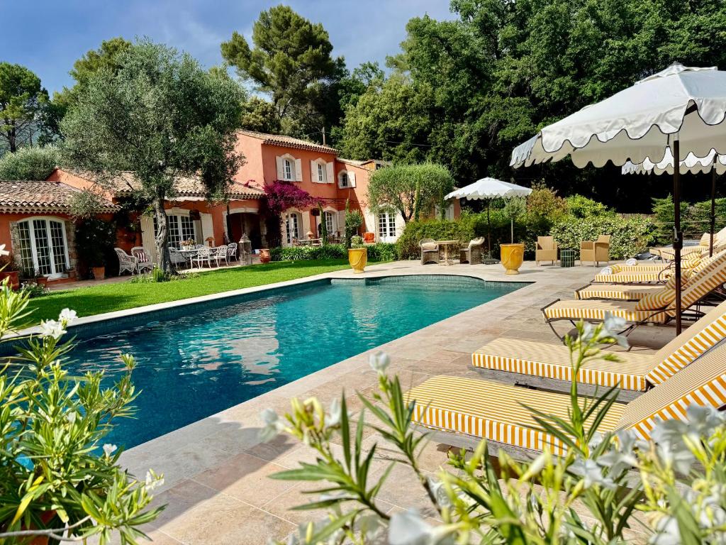a swimming pool with lounge chairs and a house at Maison Casasand Maison d'hôtes de charme in Grasse