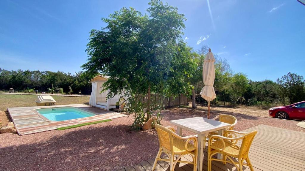 a patio with a table and an umbrella and a pool at CAN DAMIA 3 in Cala Saona