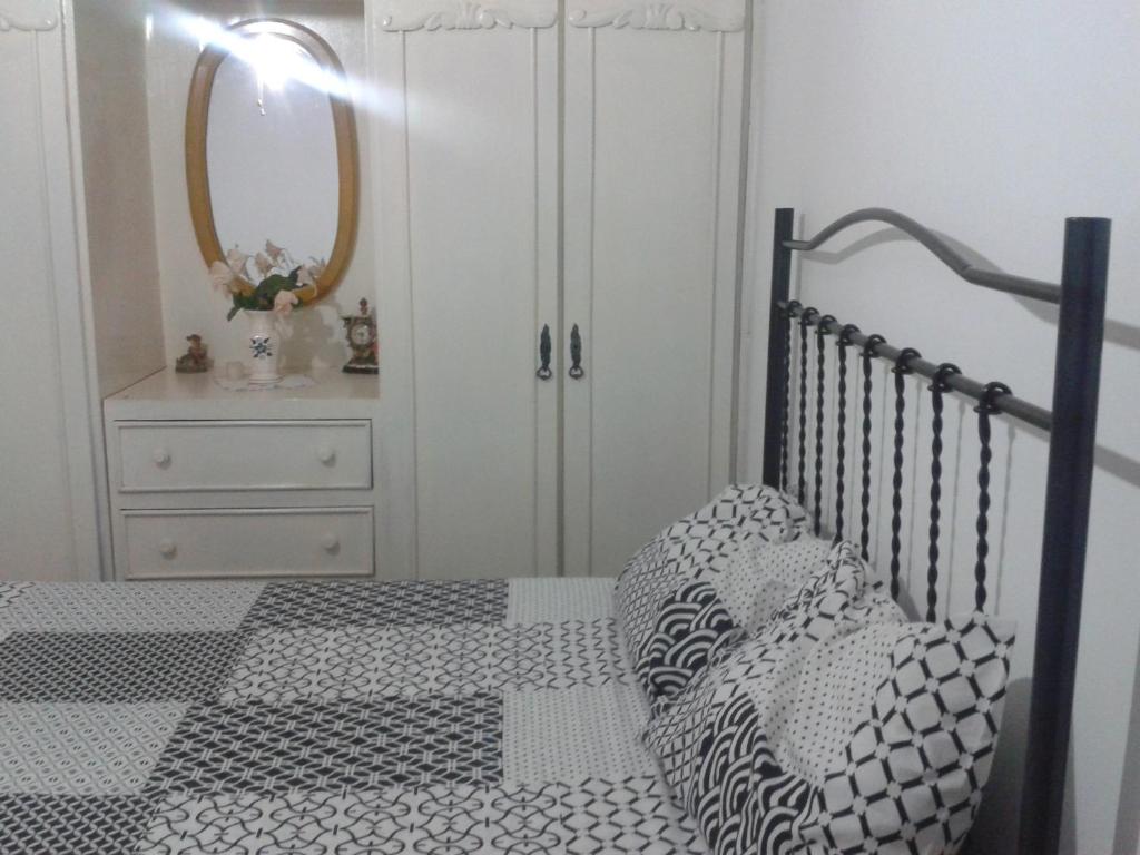 1 dormitorio con 1 cama y vestidor con espejo en Pousada Ana Poipa, en Goiânia