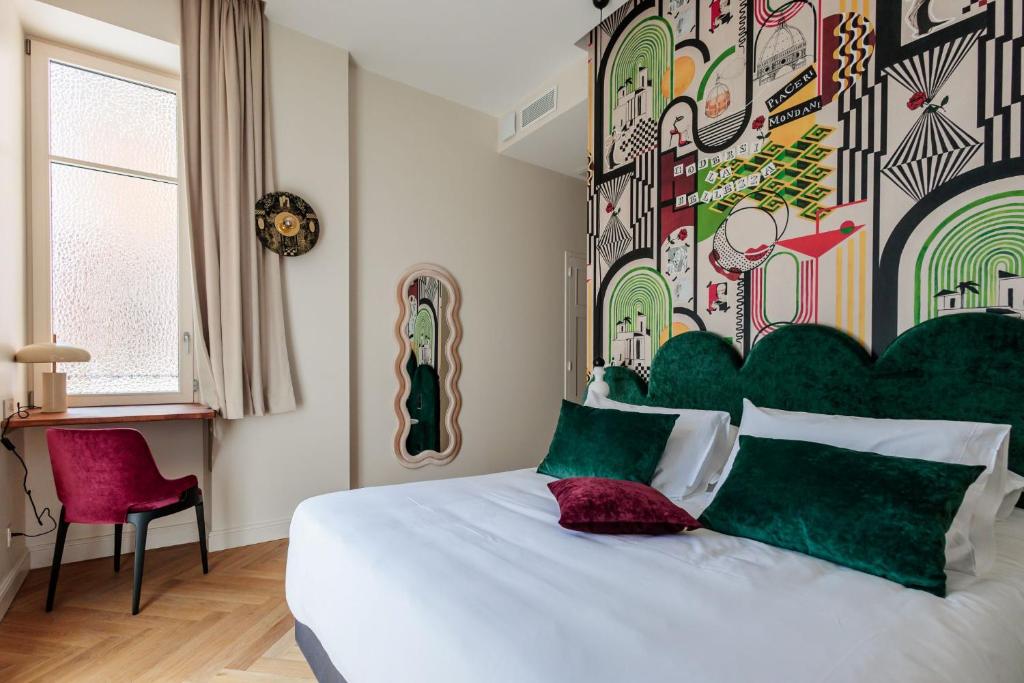 a bedroom with a large bed with a colorful wall at La Villa Kara in Romans-sur-Isère